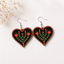 Black heart-shaped wooden earrings with hand-painted red tulip floral folk art design