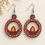 Diwali diya wooden earrings for women – oval cut-out dangler with beadwork pattern in red, orange and turquoise
