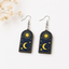 Celestial sun and moon wooden earrings with stars navy blue background spiritual cosmic jewelry for women