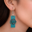 Teal rectangular wooden earrings with daisy flower cutout design