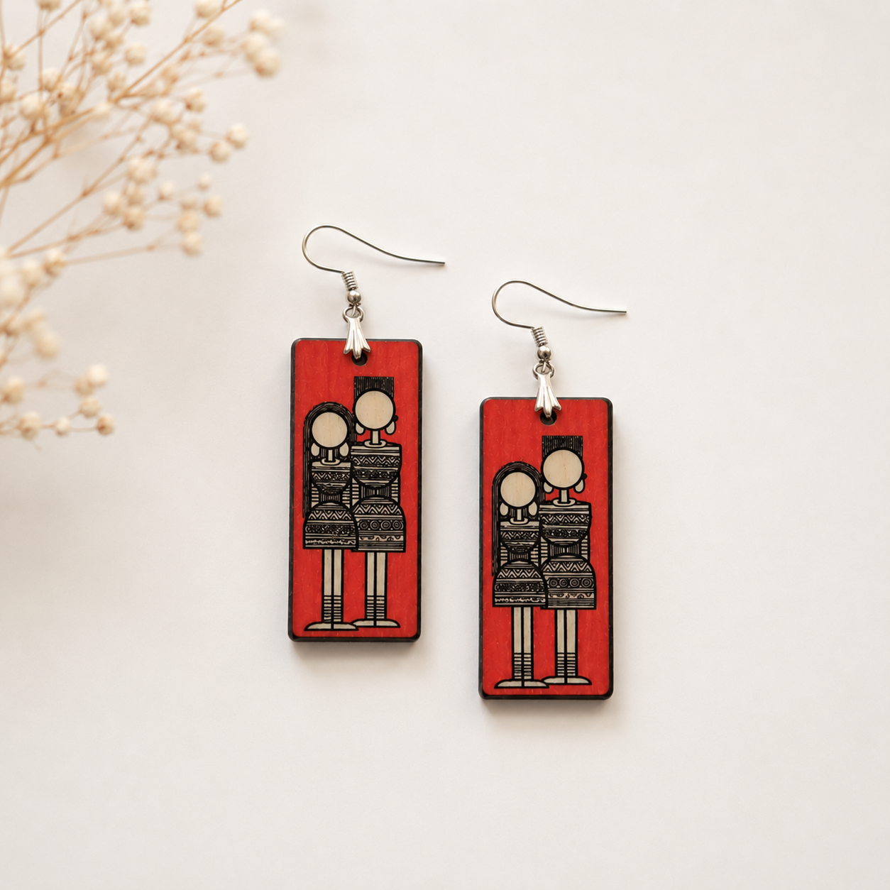 Handcrafted Warli art wooden earrings for women with red rectangular design and traditional tribal illustration on a minimal neutral background. Main image