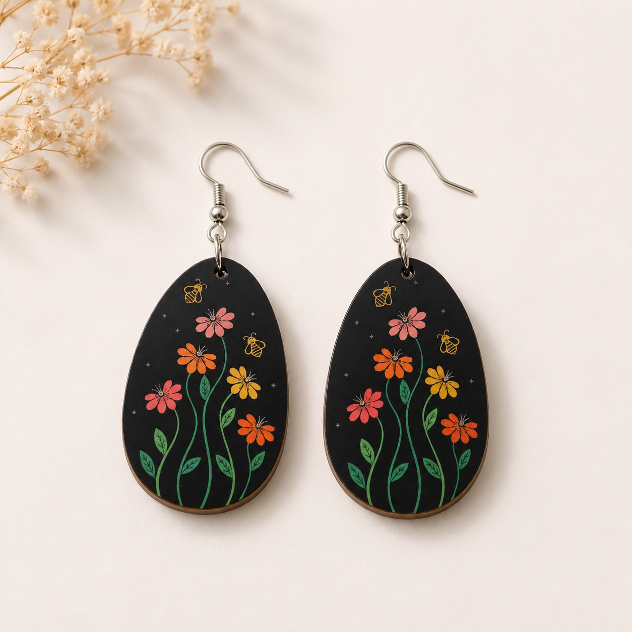 Midnight Wildflower wooden earrings for women featuring colorful floral blooms and bee illustrations on a black teardrop design with lightweight fish hook ear wires.