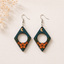 Moon Blossom wooden earrings with crescent moon, stars and orange floral artwork in geometric diamond shape for women.