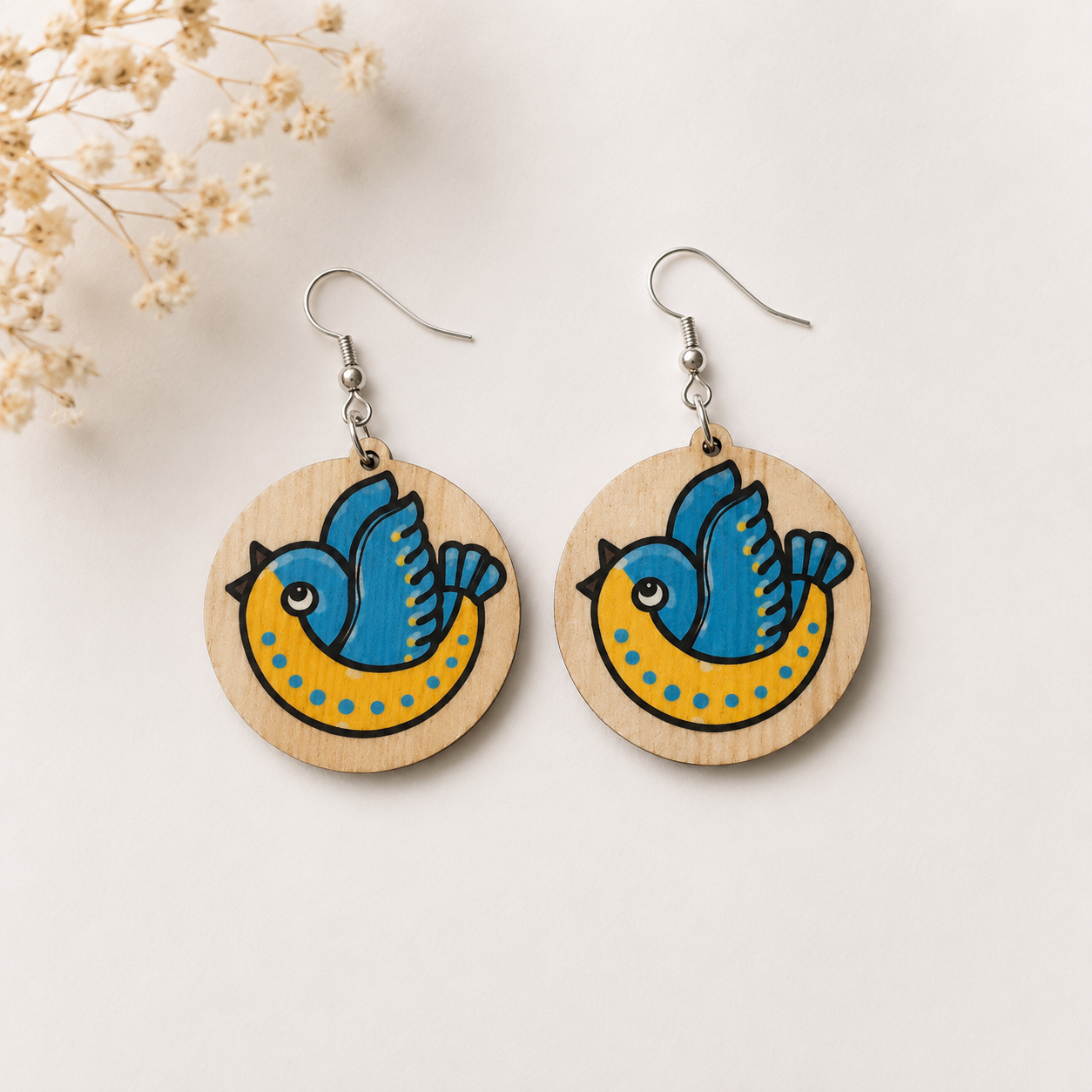 Round wooden bluebird earrings with blue and yellow bird illustration on natural wood
